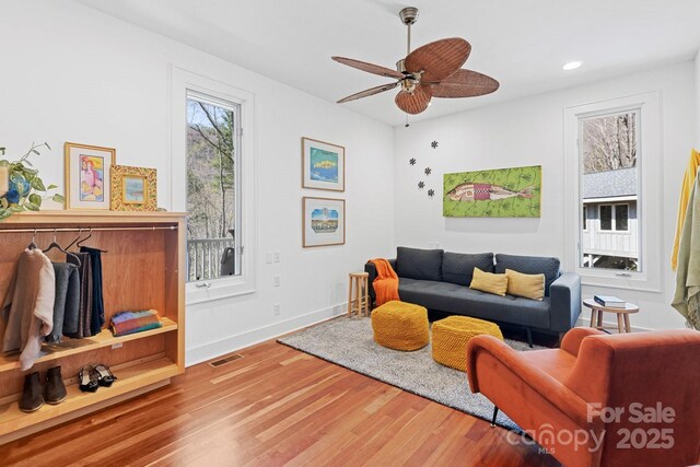 living area featuring ceiling fan, visible vents, wood finished floors, baseboards, and recessed lighting