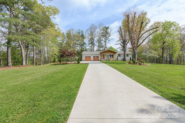 single story home featuring concrete driveway, a front yard, and an attached garage