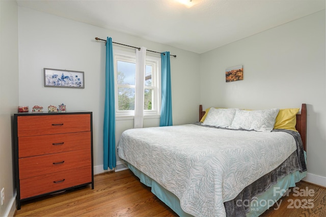 bedroom featuring wood finished floors and baseboards