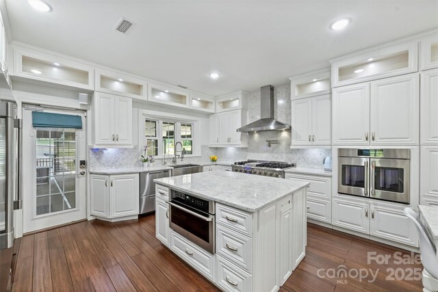 3009 Brooks Mill Ln, Wingate, NC 28174 - kitchen with wall chimney exhaust hood, stainless steel appliances, a sink, white cabinets, and dark wood-style flooring