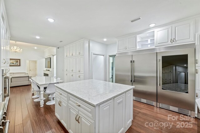 3009 Brooks Mill Ln, Wingate, NC 28174 - kitchen with white cabinetry, dark wood-type flooring, a center island, light stone countertops, and recessed lighting