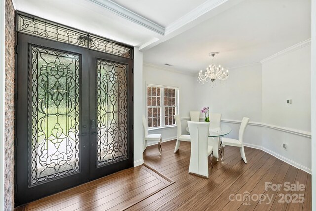 3009 Brooks Mill Ln, Wingate, NC 28174 - entrance foyer with french doors, ornamental molding, a chandelier, wood finished floors, and baseboards
