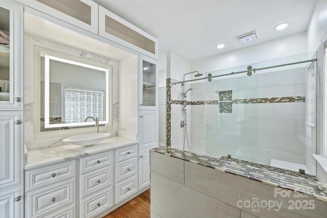 3009 Brooks Mill Ln, Wingate, NC 28174 - bathroom with a tile shower, wood finished floors, and vanity