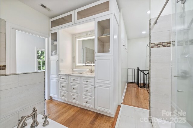 3009 Brooks Mill Ln, Wingate, NC 28174 - full bath featuring a shower with shower door, vanity, wood finished floors, and recessed lighting