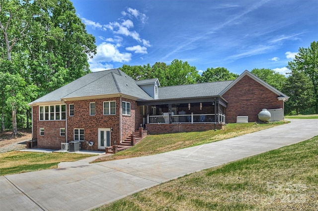 3009 Brooks Mill Ln, Wingate, NC 28174 - view of front facade with brick siding, a front yard, a sunroom, and driveway