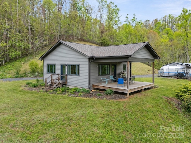 630 Graybeal Holw, Creston, NC 28615 - rear view of property featuring a yard, a deck, roof with shingles, and a wooded view