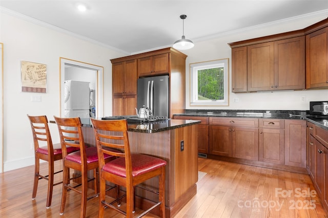 630 Graybeal Holw, Creston, NC 28615 - kitchen with freestanding refrigerator, light wood-type flooring, a center island, crown molding, and a breakfast bar area