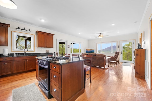 630 Graybeal Holw, Creston, NC 28615 - kitchen featuring gas range, a sink, a breakfast bar, light wood-type flooring, and a center island