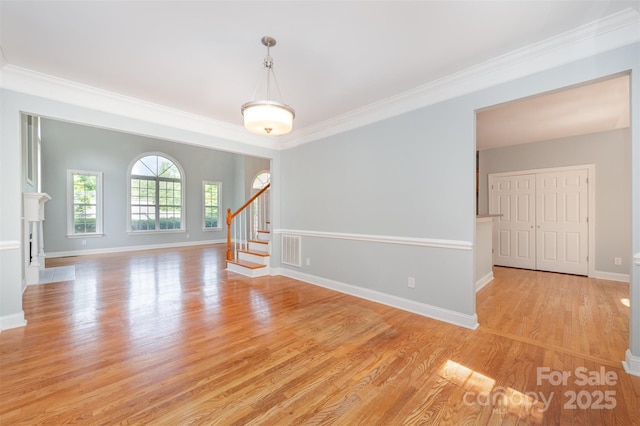 unfurnished room with baseboards, visible vents, ornamental molding, and light wood-style floors