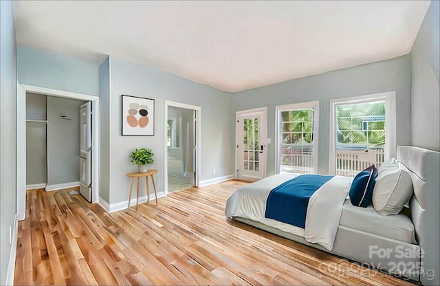bedroom featuring baseboards, ensuite bathroom, and light wood-type flooring