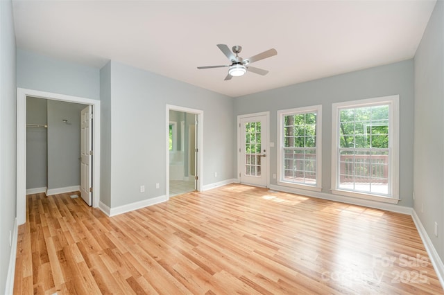 interior space featuring a ceiling fan, baseboards, and light wood-type flooring