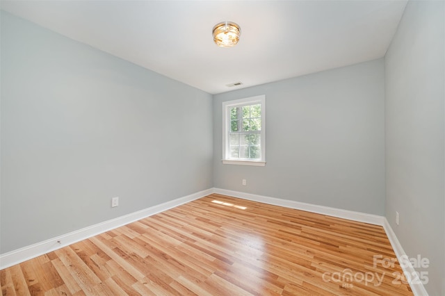 unfurnished room featuring baseboards and light wood-type flooring