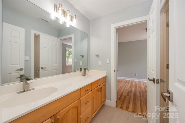 full bathroom with double vanity, tile patterned floors, visible vents, and a sink