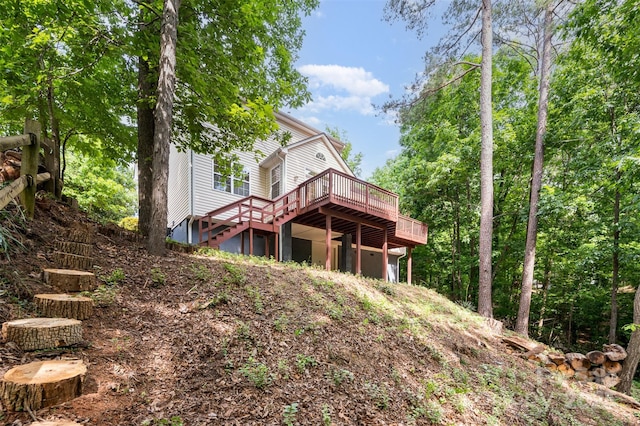 rear view of house with a wooden deck and a garage