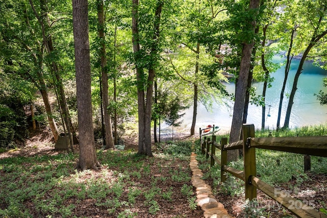 exterior space featuring fence and a water view