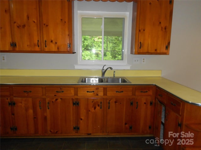 kitchen with brown cabinets, light countertops, and a sink