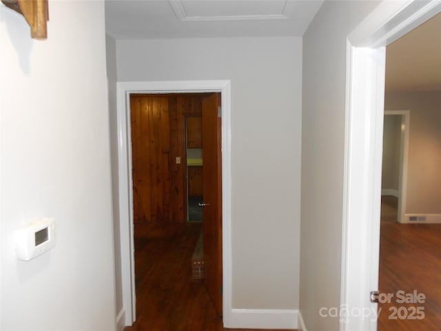 hallway featuring dark wood-style floors and baseboards