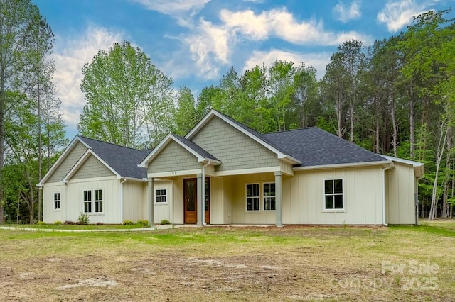 craftsman inspired home featuring board and batten siding, a shingled roof, and a front yard