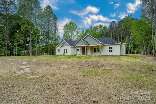 view of front of property featuring board and batten siding, a porch, and a front lawn