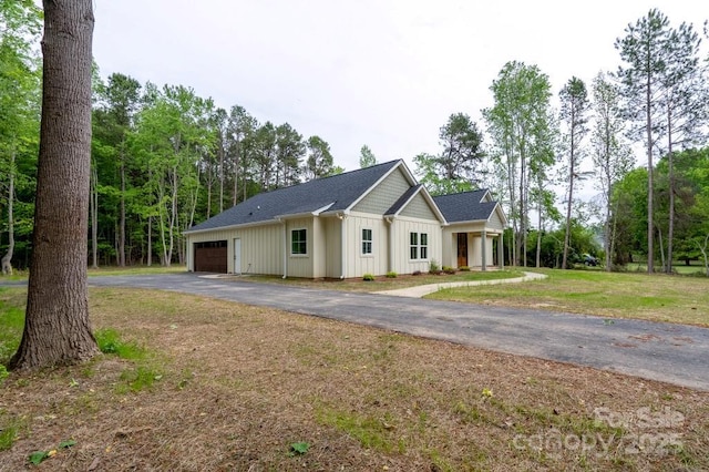 view of front facade featuring a garage, board and batten siding, driveway, and a shingled roof