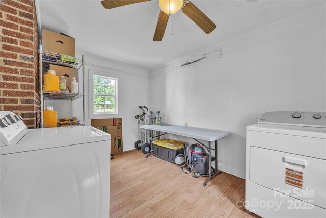 laundry room with laundry area, a ceiling fan, light wood finished floors, ornamental molding, and washer and dryer