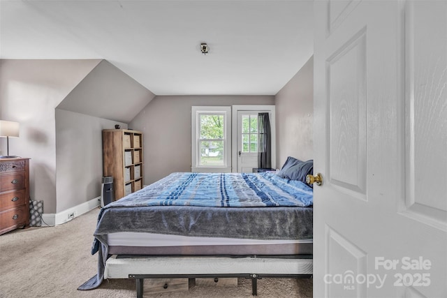 bedroom with baseboards, carpet, and lofted ceiling