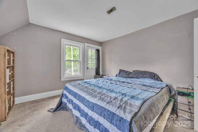 bedroom with baseboards, carpet, and lofted ceiling