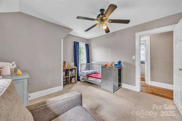 bedroom with light colored carpet, baseboards, and ceiling fan