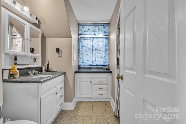 bathroom featuring vanity, baseboards, and tile patterned floors