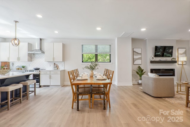 dining area with light wood-style flooring, recessed lighting, and baseboards