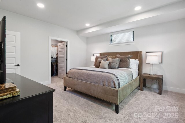 bedroom with light colored carpet, a spacious closet, recessed lighting, and baseboards