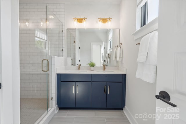 full bathroom with a shower stall, double vanity, tile patterned floors, and baseboards