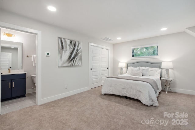 bedroom featuring ensuite bath, baseboards, light carpet, recessed lighting, and a closet