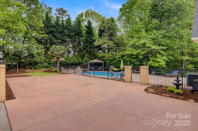 view of pool with central AC, fence, a patio, a fenced in pool, and a gazebo