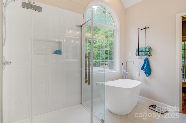 full bathroom featuring baseboards, lofted ceiling, a soaking tub, and a shower stall