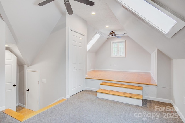 bonus room with ceiling fan, carpet, recessed lighting, baseboards, and lofted ceiling with skylight