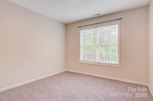 unfurnished room with baseboards, carpet floors, and visible vents