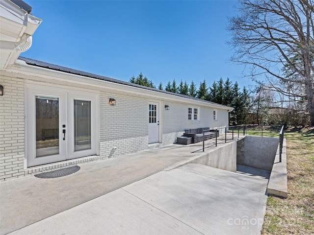 back of property with a patio and brick siding