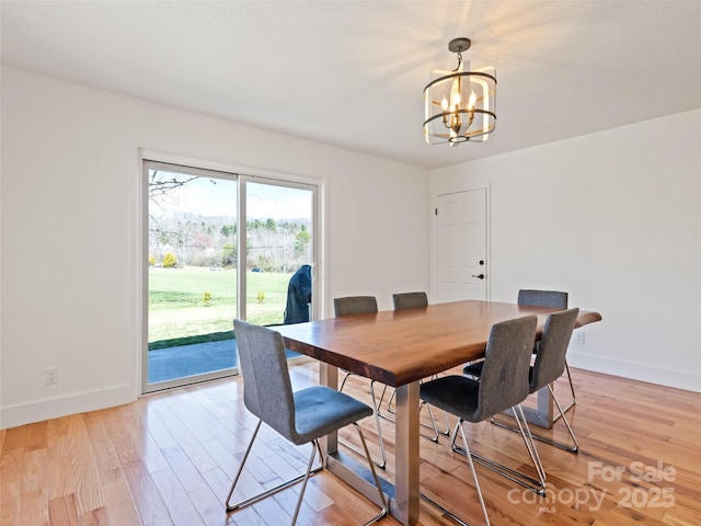 dining room with baseboards, a chandelier, and light wood-style floors