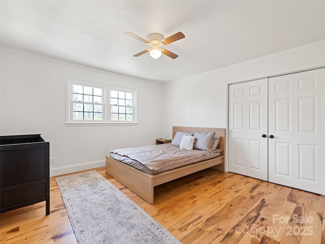 bedroom featuring a closet, ceiling fan, baseboards, and light wood-type flooring