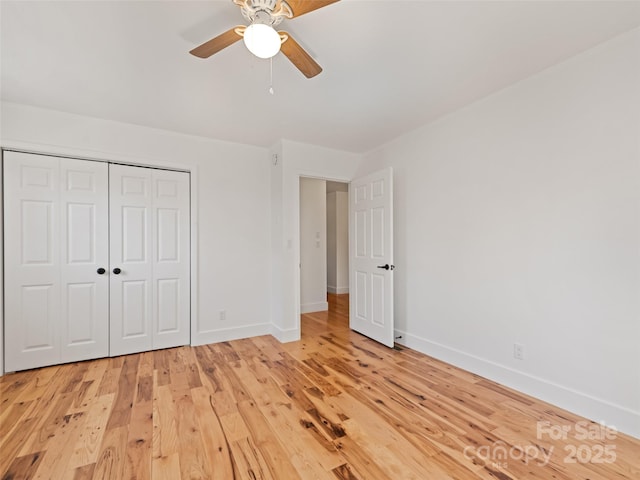 unfurnished bedroom featuring light wood-type flooring, a closet, and baseboards