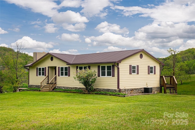view of front of house featuring a front lawn, metal roof, and cooling unit