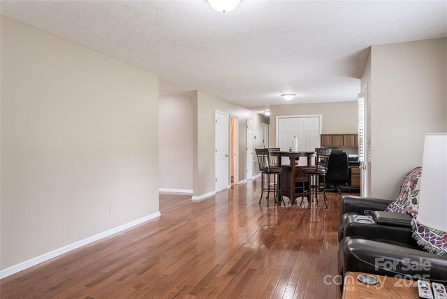 living area with baseboards and hardwood / wood-style floors