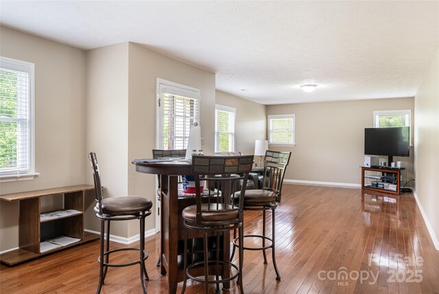 dining space featuring baseboards and hardwood / wood-style floors