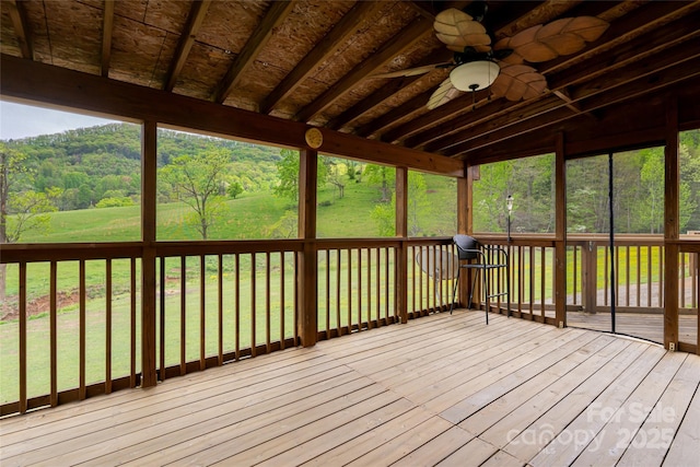 deck featuring a yard, a forest view, and ceiling fan
