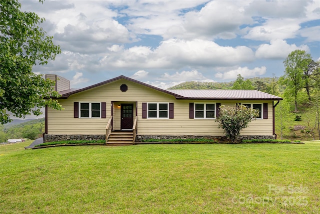 ranch-style house featuring a chimney, a front yard, and metal roof