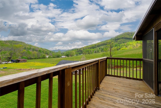 wooden deck featuring a lawn and a mountain view
