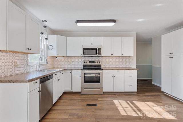 kitchen with a sink, white cabinetry, light wood-style flooring, and stainless steel appliances