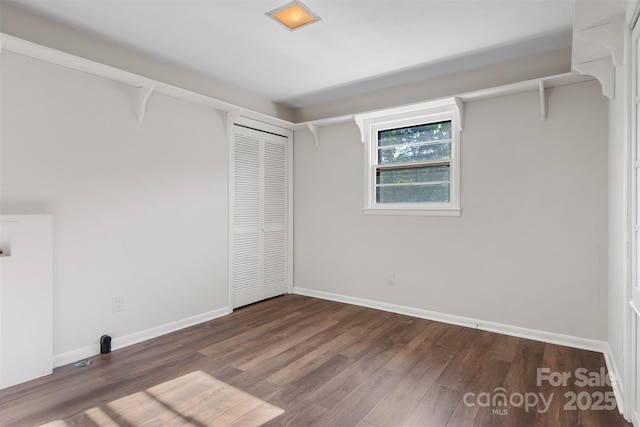 interior space with baseboards and wood finished floors