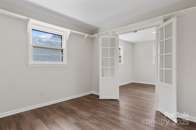 unfurnished room with dark wood-style flooring and baseboards